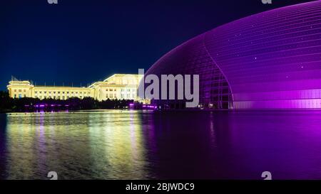 Beijing / China - October 10, 2018: National Centre for the Performing Arts and National People`s Congress, reflecting in a lake at night in Beijing, Stock Photo